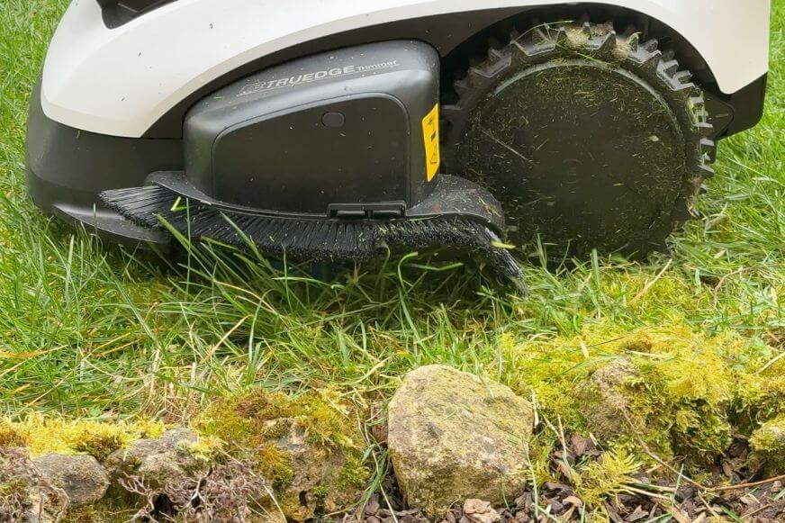 ECOVACS GOAT O1200 LiDAR PRO Mähroboter mit sauberem Kantenschnitt direkt an einer geraden Gartenmauer